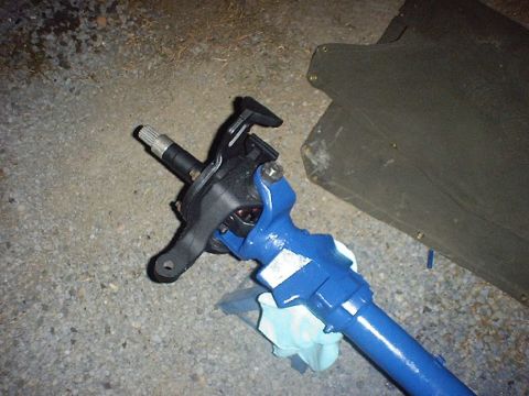 1988 Ford Bronco - A close-up of a freshly painted blue steering component, likely part of a vehicle's steering system, is shown on the ground.