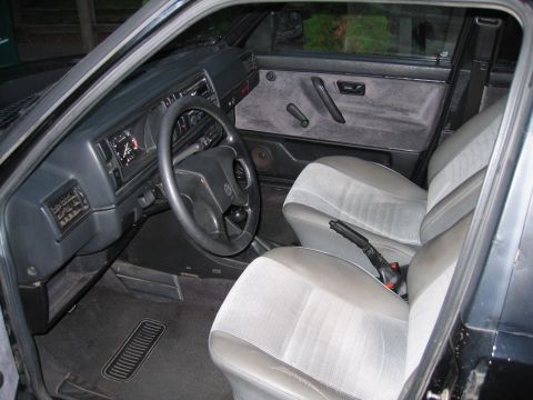 1987 Volkswagen Golf - The interior of a 1987 Volkswagen Golf is visible, grey seats and a dark dashboard.