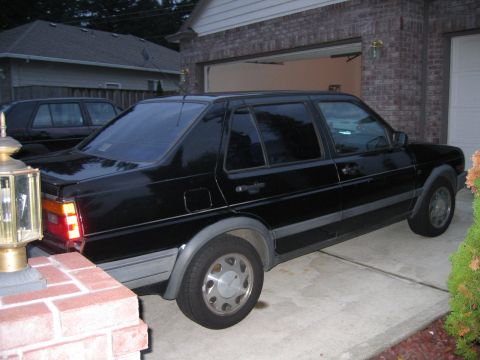 1987 Volkswagen Golf - Black sedan parked in a driveway. The body style suggests it is not a 1987 Volkswagen Golf.