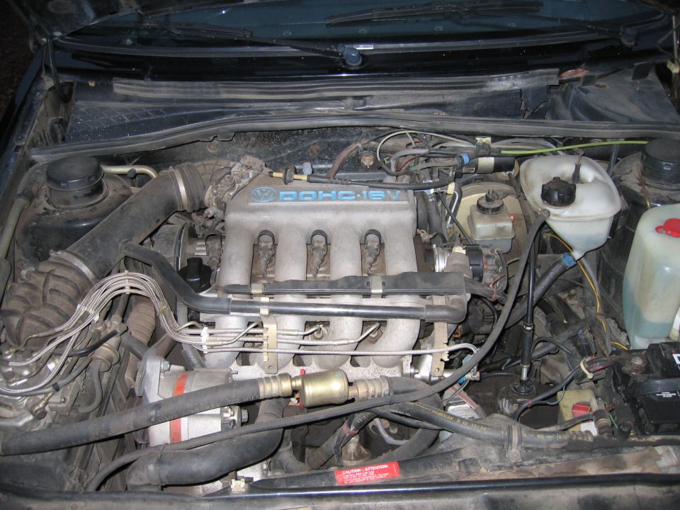 Engine bay of a Volkswagen with DOHC 16V engine cover. Visible text includes 'SUPERMOTORS'