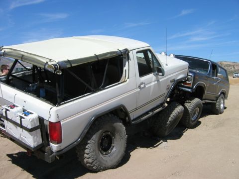 1985 Ford Bronco - A modified 1985 Ford Bronco, converted to a 6x6, is seen off-road with another SUV behind it.