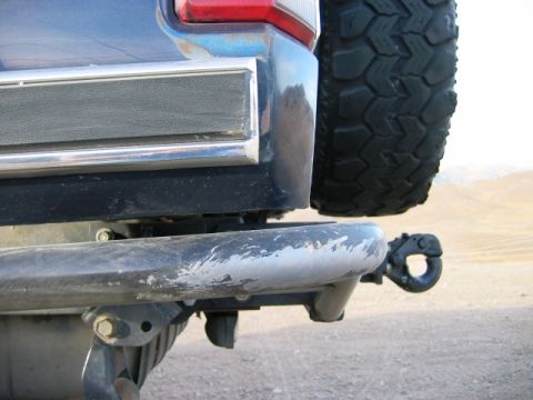 1985 Ford Bronco - Rear view of a 1985 Ford Bronco showing the bumper, spare tire, and tow hitch.