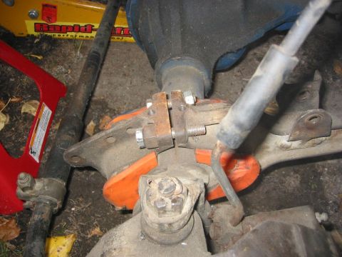1985 Ford Bronco - Close-up of vehicle suspension components, including a driveshaft and differential housing, with orange bushings visible.