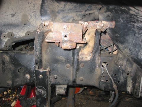 1985 Ford Bronco - Close-up view of a rusted bracket assembly attached to a vehicle's frame, likely a part from a disassembled vehicle.