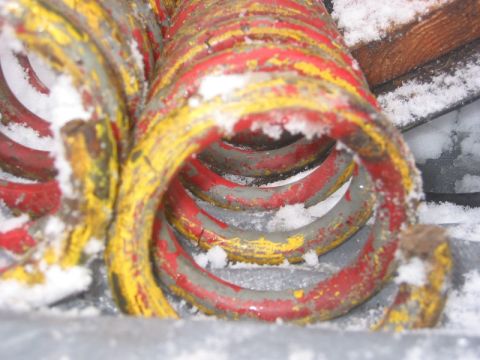 1985 Ford Bronco - These suspension springs are covered in snow, suggesting they are stored outdoors or were recently removed from a vehicle in winter conditi…