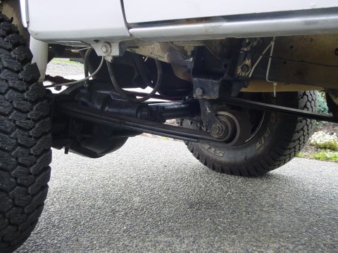 1987 Ford Bronco - Close-up view of the rear suspension components and a tire on a vehicle.