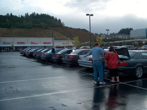 1999 BMW 7 Series - A line of BMW 7 Series sedans are parked in a lot on a cloudy day.