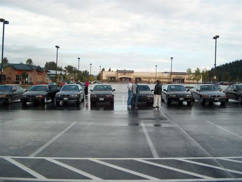 1999 BMW 7 Series - A group of 1999 BMW 7 Series cars gathered in a parking lot on a cloudy day.