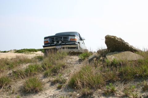 1993 Ford Bronco - This 1992 Ford Bronco navigates a sandy, rocky landscape under a clear sky.