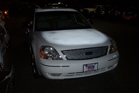 1993 Ford Taurus - This white sedan's grille and headlights do not match a 1993 Ford Taurus, suggesting a different model year.