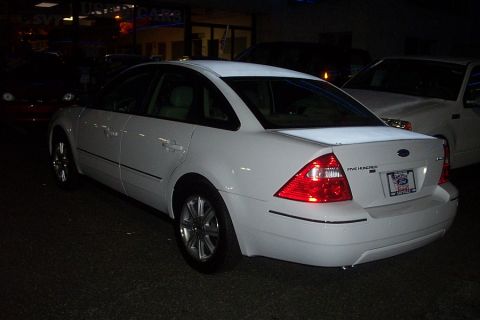 1993 Ford Taurus - This white Ford sedan, identified as a Five Hundred, is parked outside at night with another vehicle behind it.