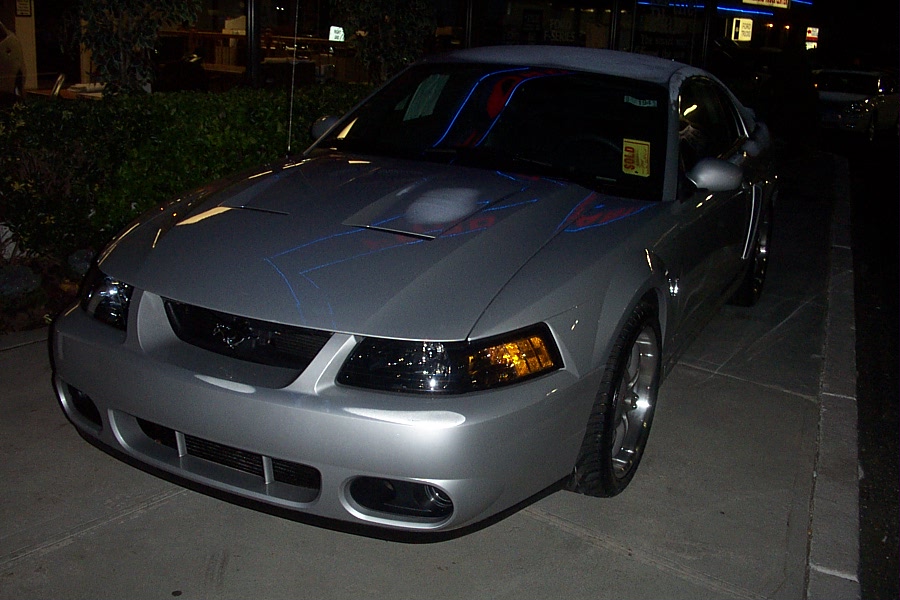 Silver coupe with hood scoop and racing stripes, front 3/4 view