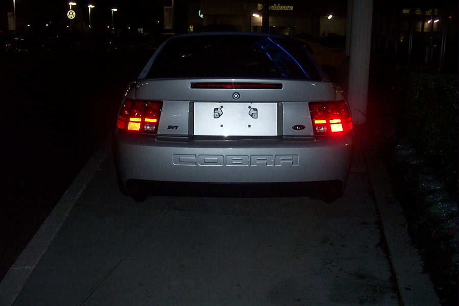 Rear view of a silver 2001 Ford Mustang Cobra with 'COBRA' embossed on the bumper and 'SVT' badge on the left taillight