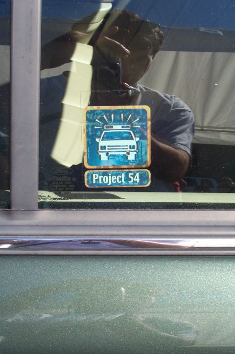 1991 Ford LTD Crown Victoria - A sticker with a police car graphic and 'Project 54' text is visible on a car window.