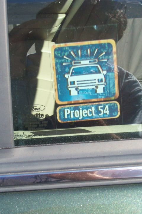 1991 Ford LTD Crown Victoria - A sticker on the car window displays a police car graphic and the words 'Project 54'.