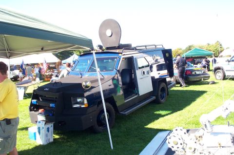 1991 Ford LTD Crown Victoria - An armored police vehicle is displayed outdoors next to a standard police car.
