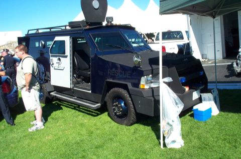 1991 Ford LTD Crown Victoria - An armored rescue vehicle with its door open is displayed outdoors on a sunny day.