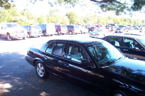 1991 Ford LTD Crown Victoria - A black sedan is parked in a lot with many other vehicles visible in the background.