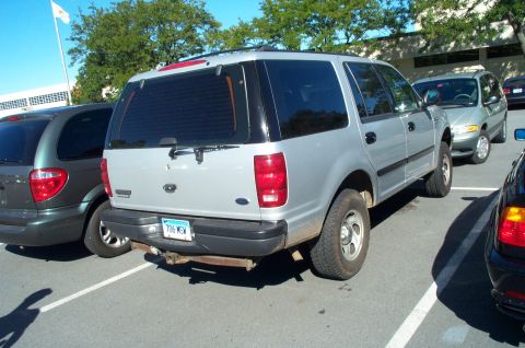 1991 Ford LTD Crown Victoria - A silver Ford Expedition is parked in a lot next to other vehicles.