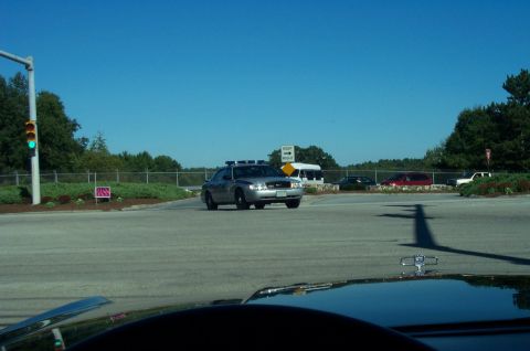 1991 Ford LTD Crown Victoria - Police car waits at intersection under a clear blue sky.