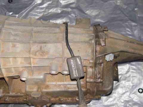 1988 Ford Bronco - Transmission housing with an attached electronic module, likely for a vehicle part.