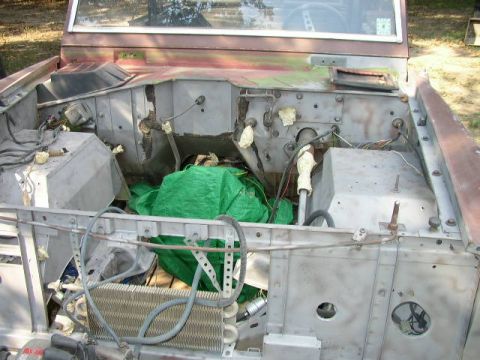 1995 Ford Bronco - The engine bay of a vehicle is shown disassembled, with various parts and wiring exposed.