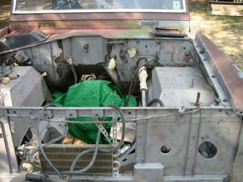 1995 Ford Bronco - Engine bay of a 1995 Ford Bronco, showing the radiator and various components covered by a green tarp.