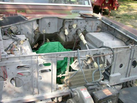 1995 Ford Bronco - The engine bay of a vehicle is shown with exposed components and wiring, suggesting it is under repair.