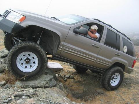1989 Ford Bronco - Modified Jeep Grand Cherokee ZJ tackling an off-road obstacle course.
