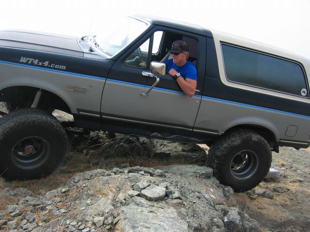 1989 Ford Bronco with WT4x4.com sticker on fender, driving over rocks
