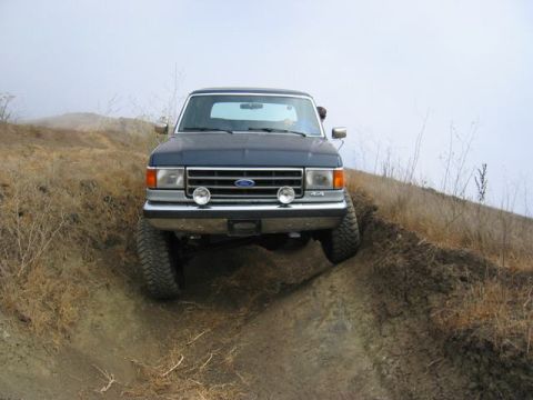 1989 Ford Bronco - This 1987 Ford F-150 navigates a steep, muddy incline during an off-road excursion.