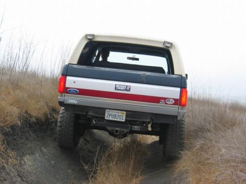 1989 Ford Bronco - This 1989 Ford Bronco is captured from the rear as it navigates a dusty, off-road trail.