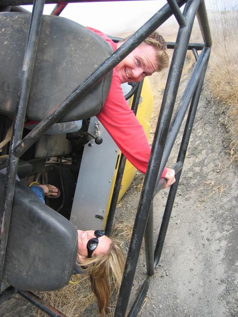 1989 Ford Bronco - Two people enjoy a ride in an off-road buggy, with a roll cage visible around them.