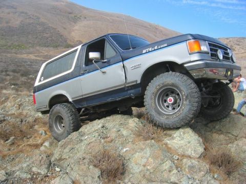 1989 Ford Bronco - This lifted 1989 Ford Bronco navigates a rocky trail, its off-road capabilities.