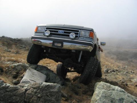 1989 Ford Bronco - This Ford Bronco is navigating a rocky incline with a driver visible.