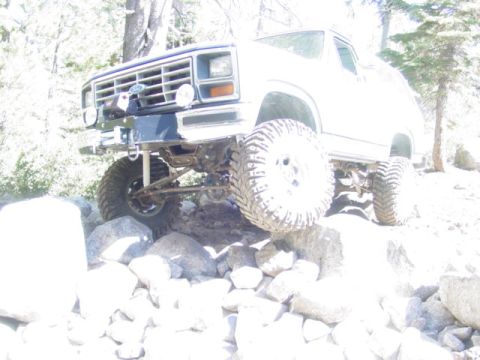 1986 Ford Bronco - A white Ford Bronco navigates a rocky terrain.