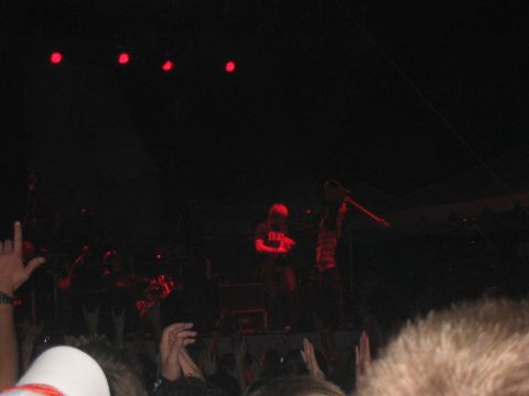 1988 Ford Bronco - A band performs on stage for a crowd at a concert, illuminated by red lights.