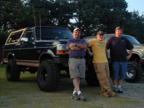 1989 Ford Bronco - Three men pose with a lifted 1989 Ford Bronco and another vehicle in the background.