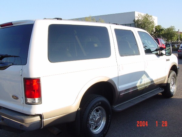 White 2000 Ford Excursion SUV, rear quarter panel and side visible, parked outdoors