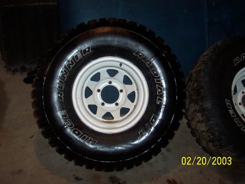 1979 Ford Bronco - Two off-road tires with white rims are shown, with text on one tire reading 'Ridge Runner Radial Dit'.