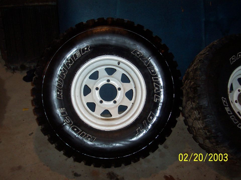 Two off-road tires with white rims, one showing 'Ridge Runner Radial Dit' text