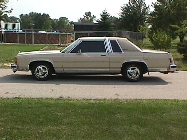 Cream two-door Ford Crown Victoria coupe, driver-side profile
