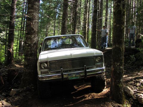 1993 Ford Bronco - A white 1973 Chevrolet K5 Blazer navigates a wooded trail with two people observing.