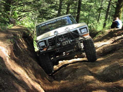 1993 Ford Bronco - This 1979 Ford Bronco navigates a challenging dirt trail, equipped with a winch and brush guard for off-road adventures.