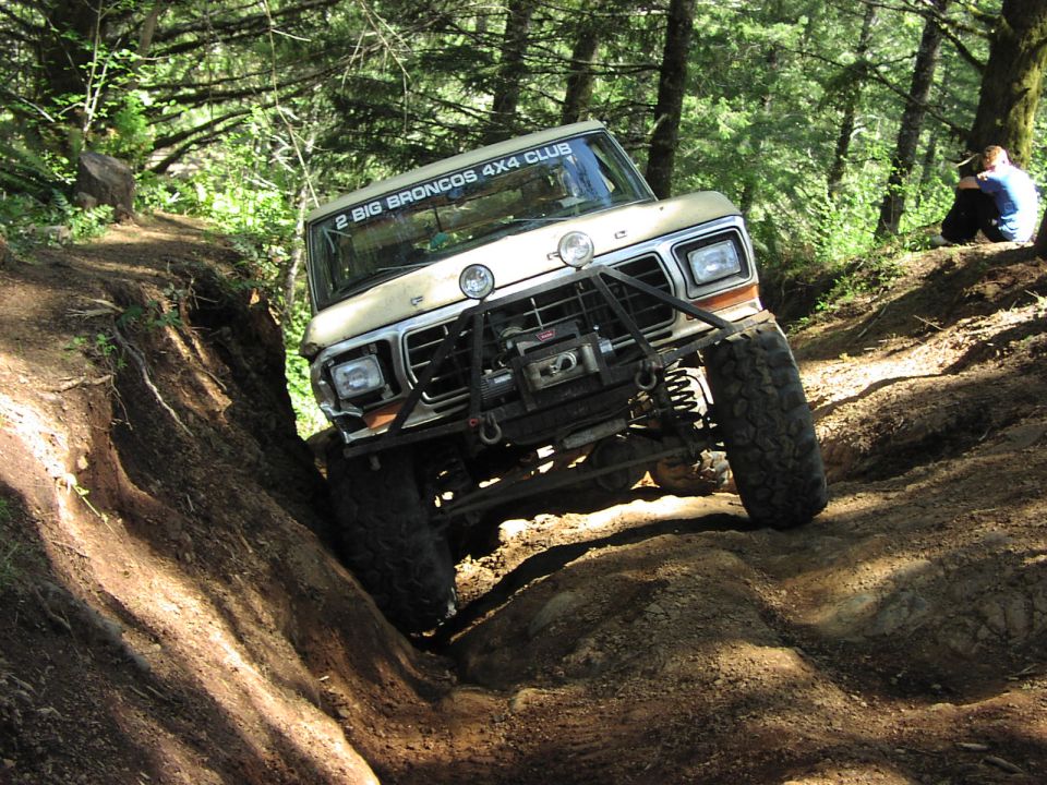 Tan 1979 Ford Bronco off-roading with a winch and brush guard