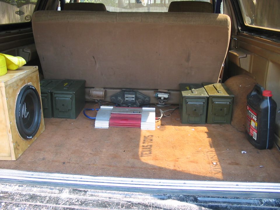 Interior cargo area with subwoofer box, amplifier, and ammo cans