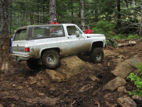 1993 Ford Bronco - This SUV is tackling a challenging off-road course in a wooded area.