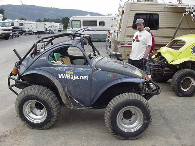 Dark VWBaja.net Beetle buggy on wide tires parked in an RV lot beside a motorhome