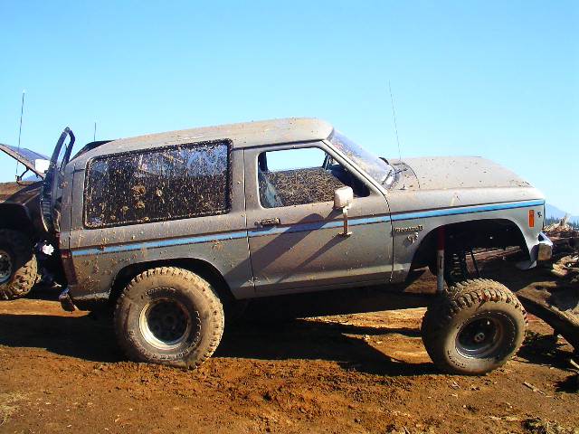 Mud-covered gray 1984 Ford Bronco II side view, lifted suspension, off-road tires