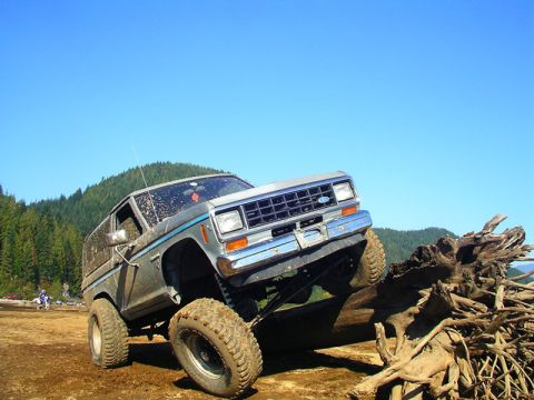 1984 Ford Bronco II - This lifted 1984 Ford Bronco II is shown navigating a challenging off-road obstacle.